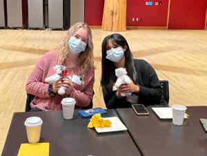Erin McClure (she/her)​ and Neha Singh (she/her)​, Clinical Research Fellow​s, receive husky plushies as a welcome gift.