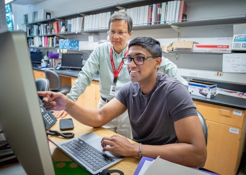 Dr. Nghiem assisting a researcher at a computer