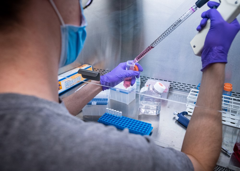 Researcher using pipette in chemical fume hood