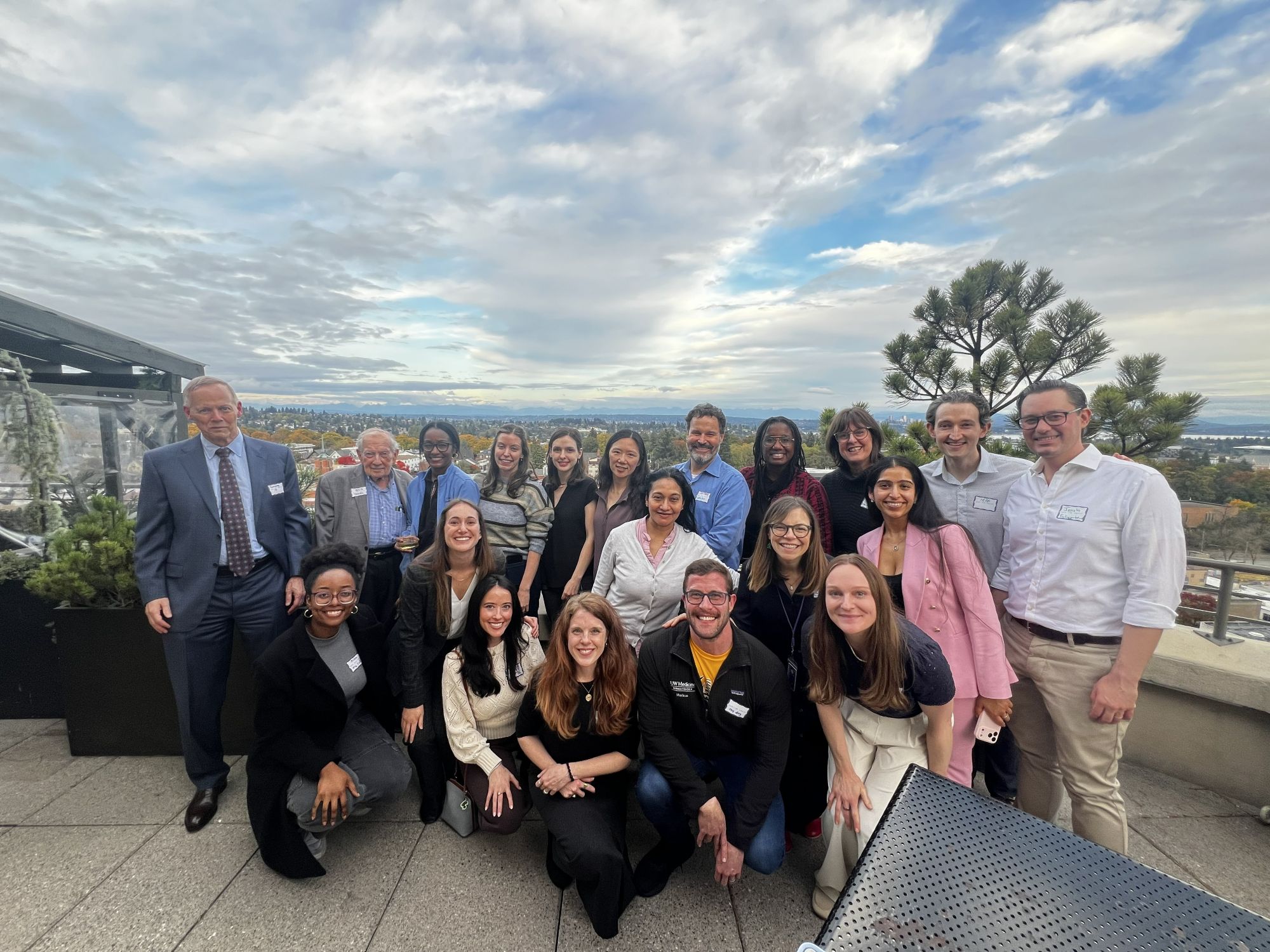 group of people standing on a rooftop patio