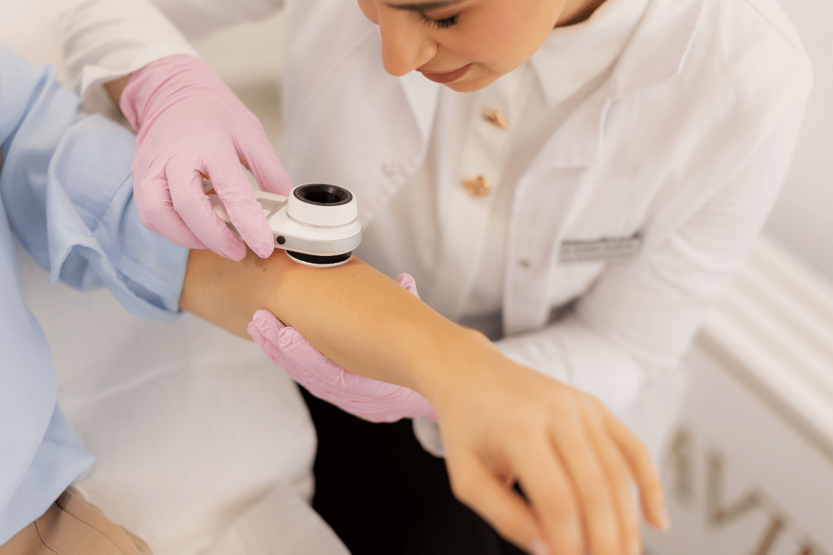 doctor using a dermatoscope on a patient's arm