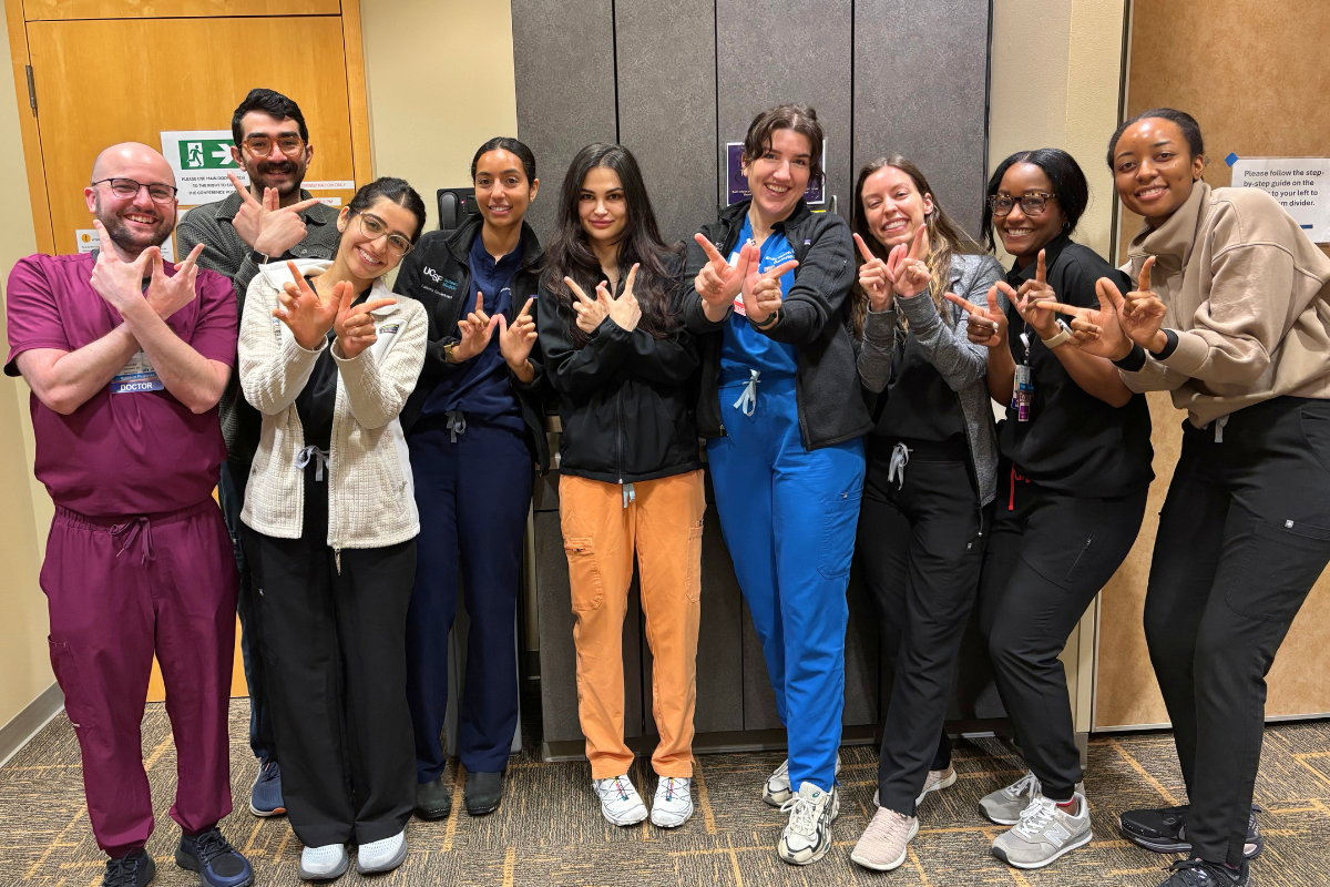 UW Residents making a "W" with their hands and smiling 