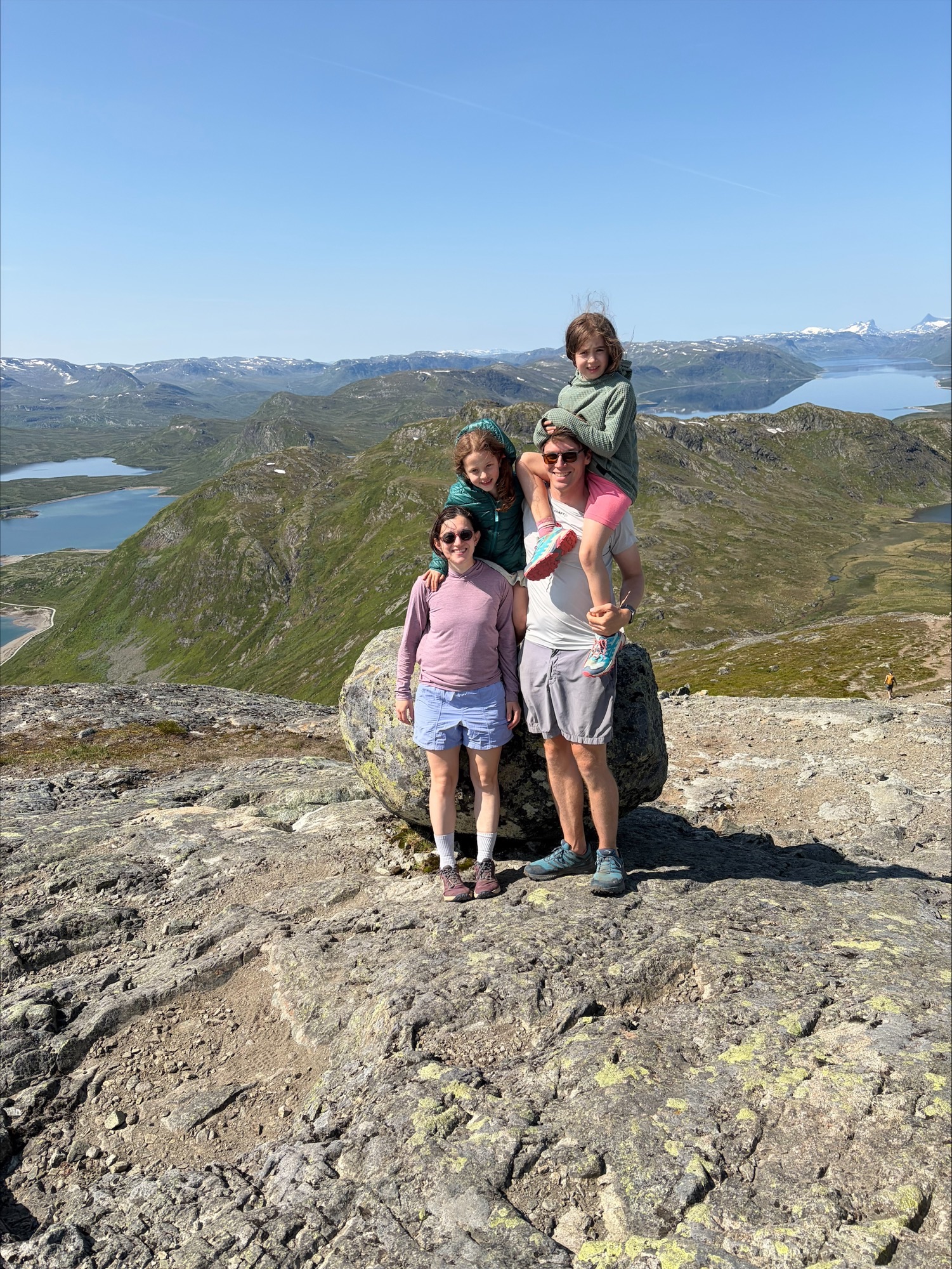 Family of 4 standing on a rock face